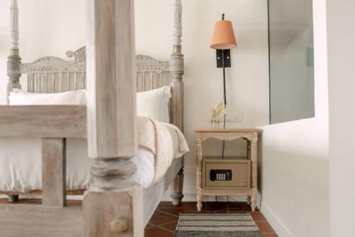 a bedroom with a bed and a table with a clock at Naomi Beach Resort - Adults only in Weligama