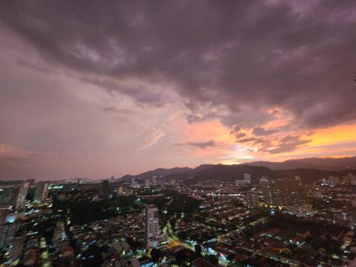 a city skyline with a cloudy sky at sunset at Urban Suites - Penang in Jelutong
