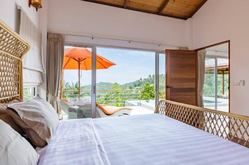 1 dormitorio con balcón y sombrilla de color naranja en Santai 2Bedrooms Villas Koh Phangan en Chaloklum