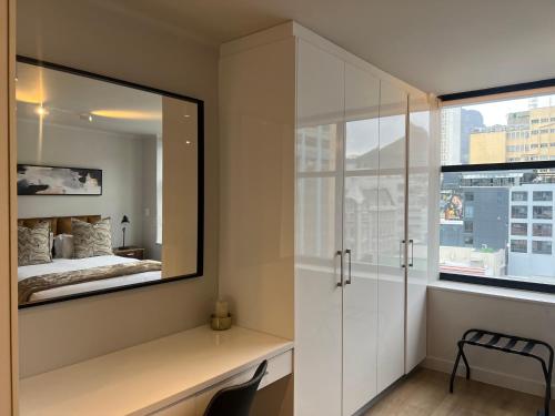 um quarto com um espelho e uma cama em The Tokyo 708 - Family Studio em Cidade do Cabo