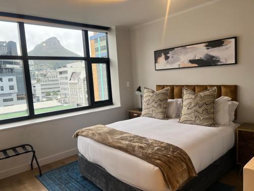een slaapkamer met een groot bed en grote ramen bij The Tokyo 708 - Family Studio in Kaapstad