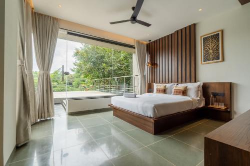 a bedroom with a bed and a large window at SaffronStays Nilufer in Nashik