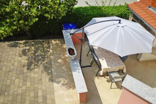 parasol siedzący obok krzesła i stołu w obiekcie Apartment PINK in Starigrad Paklenica only 200 m from the sea w mieście Starigrad-Paklenica