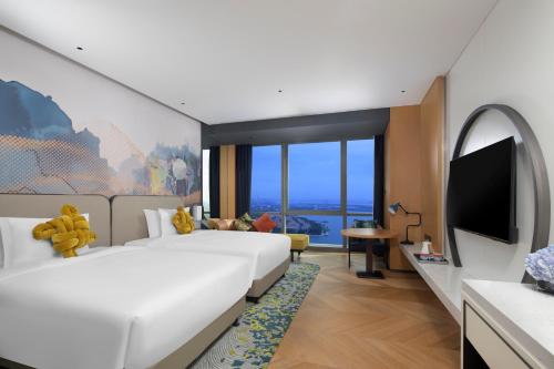 蘇州市にあるM Social Hotel Suzhouのベッド2台、薄型テレビが備わるホテルルームです。