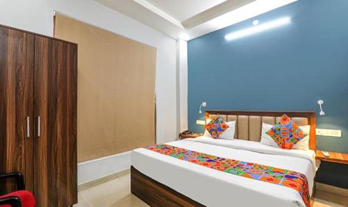 een slaapkamer met een groot bed en een houten kast bij FabExpress North Inn in Chinhat