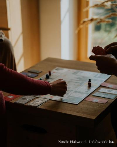 Eine Gruppe von Leuten, die ein Brettspiel auf einem Tisch spielen in der Unterkunft Nørdic Balatøn Badacsony in Badacsonytördemic
