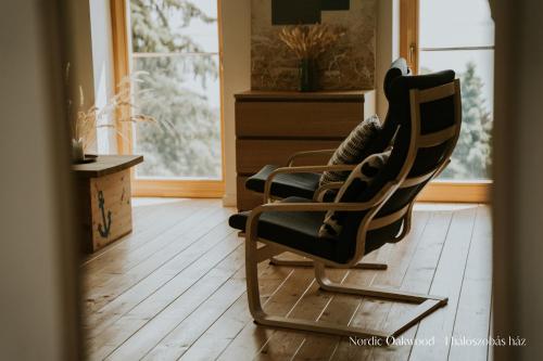 una sedia a dondolo in un soggiorno con finestra di Nørdic Balatøn Badacsony a Badacsonytördemic