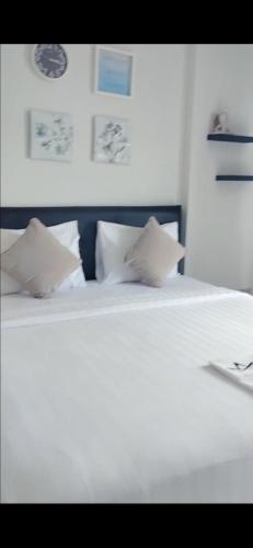 duże białe łóżko z 2 poduszkami w obiekcie Aeropolis 803b w mieście Balikpapan