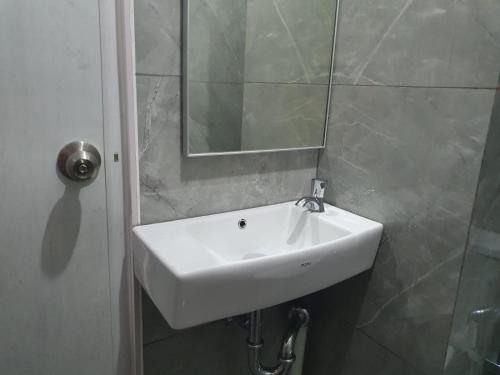 lavabo blanco en el baño con espejo en sayana apartment tower cha, en Hutanhawit