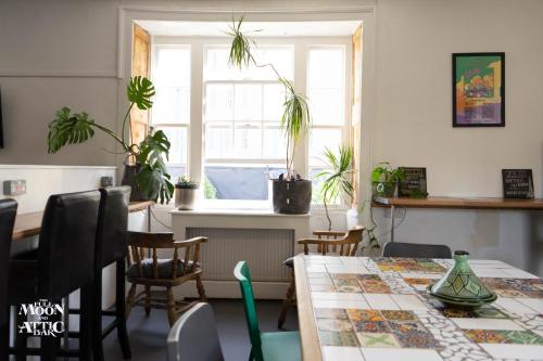 uma sala de jantar com uma mesa e alguns vasos de plantas em The Full Moon Backpackers em Bristol