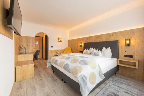 Habitación de hotel con cama y TV de pantalla plana. en Hotel Alphof Stubaital, en Fulpmes