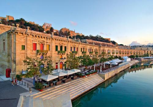 a large building next to a river withumerableumerableumerableumerableumerableumerableumerableumerable at Tranquil Studio in the Heart of Valletta in Valletta
