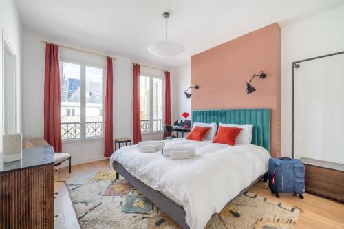 une chambre avec un grand lit avec des oreillers rouges dans l'établissement Rare, center, luxury apartment with roof view, à Paris