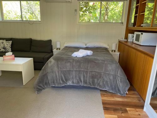 een slaapkamer met een groot bed en een bank bij Canberra Hospital Locum Welcome in Harman