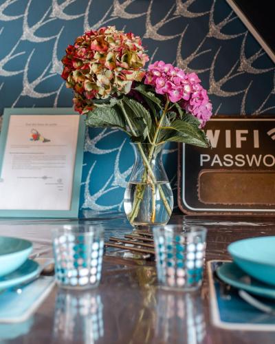 un vase avec des fleurs assis sur une table dans l'établissement Gîte de la Mer sur le port de plaisance de Lézardrieux Bretagne, à Lézardrieux
