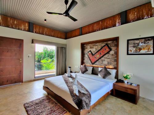 een slaapkamer met een bed en een bakstenen muur bij Lion Signature Family Resort in Sasan Gir