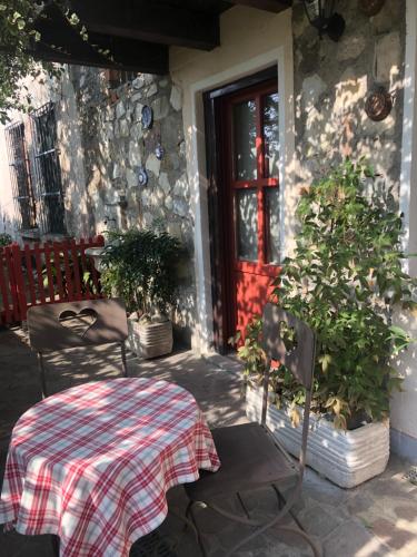a table and chairs on a patio with a red door at Antica Casa Fenaroli in Iseo