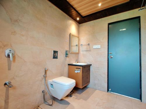 a bathroom with a toilet and a sink at Lion Signature Family Resort in Sasan Gir