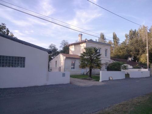 uma casa branca com uma cerca à frente. em Le studio médocain em Cussac-Fort-Medoc