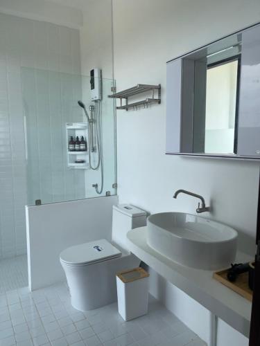 ein Badezimmer mit einem Waschbecken, einem WC und einem Spiegel in der Unterkunft Amidst wind in Wang Nam Khieo