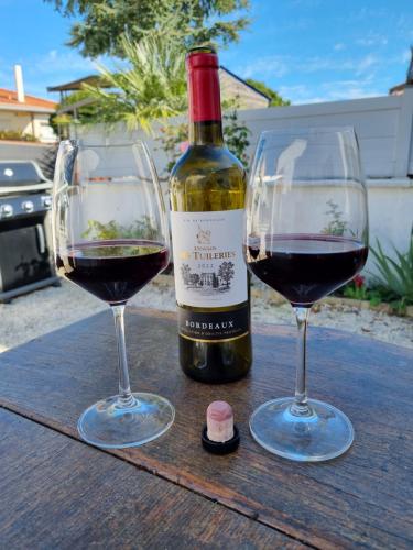 deux verres de vin rouge assis sur une table en bois dans l'établissement Gîte Chez Gladys, à Chenac Saint Seurin D'uzet