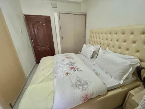 uma cama com lençóis brancos e flores em Kigali Swift Rentals em Kigali