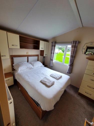 莫珀斯的住宿－Woods Lodge，一间卧室配有一张大床和两条毛巾