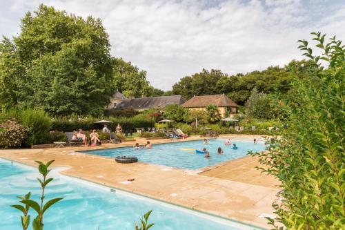 a group of people swimming in a swimming pool at Camping Castels Chateau de Chanteloup in La Croix