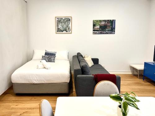 - un salon avec un canapé et un lit dans l'établissement Townhouses by Readyset at Beach, à Melbourne