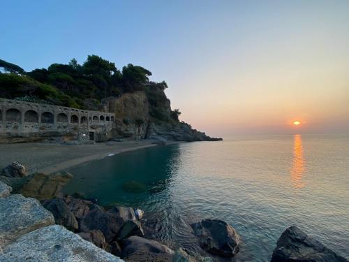 a sunset over a beach with the ocean at Il mare in Piazza in Albisola Superiore