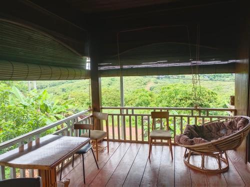 a porch with a hammock and chairs on a deck at Banlung Hill Top House &Trekking in Phumĭ Pôy