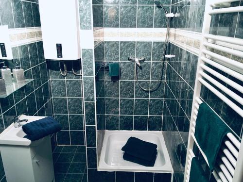 La salle de bains est pourvue d'un lavabo et d'une douche avec des serviettes bleues. dans l'établissement Chata na sjezdovce, à Josefův Důl