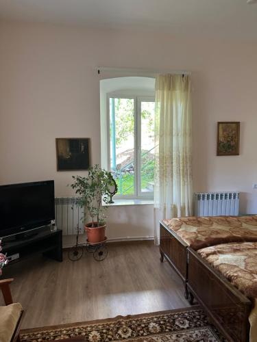 a bedroom with a bed and a large window at Sweet Home in Dilijan