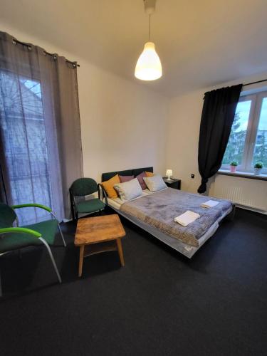 1 dormitorio con 1 cama, 1 silla y ventanas en Charmed HomeStay - Zaczarowany, en Varsovia