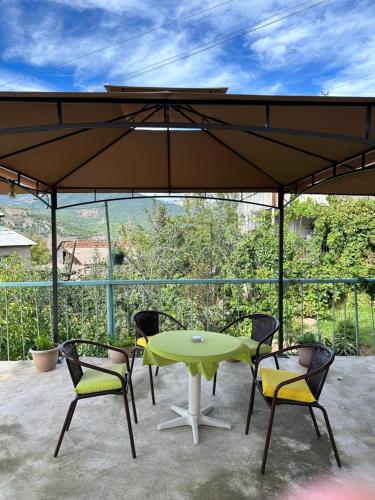 a patio with a table and chairs under a large umbrella at Sweet Home in Dilijan