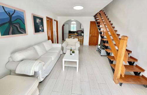 sala de estar con sofá blanco y escalera en Sunlight Place Bungalow, en San Bartolomé