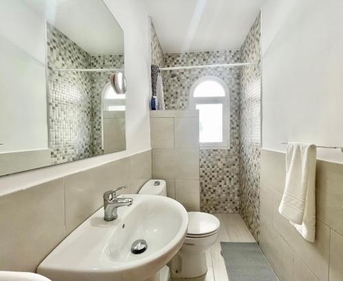 a white bathroom with a sink and a toilet at Sunlight Place Bungalow in San Bartolomé de Tirajana