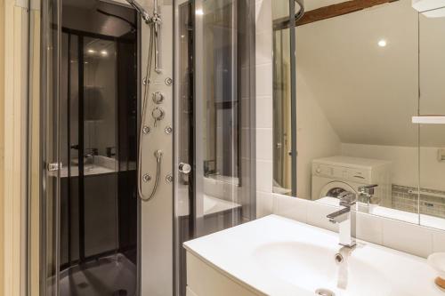 a white bathroom with a sink and a shower at Appartement du Commun au Château de Chanteloup in La Croix