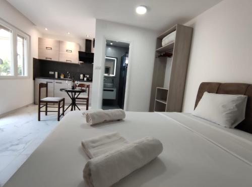 a bedroom with a large white bed and a kitchen at Nikolic Apartment 2 in Leskovac