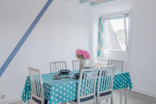 a dining room with a blue table and chairs at Gîte de la Marina dans la presqu'île de Lézardrieux in Lézardrieux