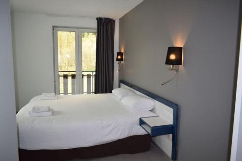 um quarto com uma cama com lençóis brancos e uma janela em HOTEL VICTORIA em Arinsal