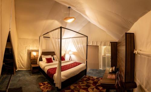 1 dormitorio con cama con dosel en una tienda de campaña en Redberry's Luxury Stay, en Somvārpet