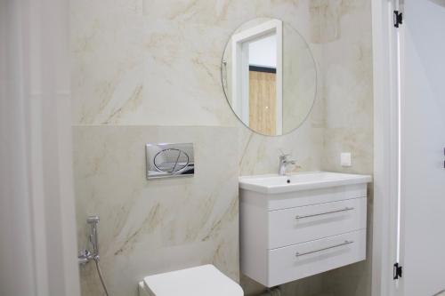a white bathroom with a sink and a mirror at Новая квартира в ЖК "Millennium Park" in Promyshlennyy