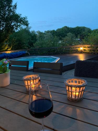 a glass of wine sitting on a wooden table at Holiday Home 'Beautifull Water' in Lanaken