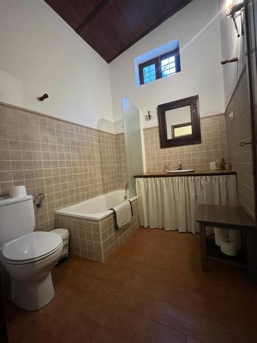 a bathroom with a toilet and a tub and a sink at Casa de campo Fuencaliente, entorno natural, chimenea, piscina in Cañete la Real