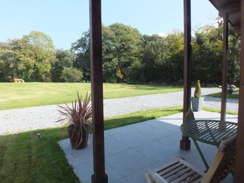 a screened in porch with a bench and a lawn at Killarney Cabins Stunning Adult Accommodation in Killarney