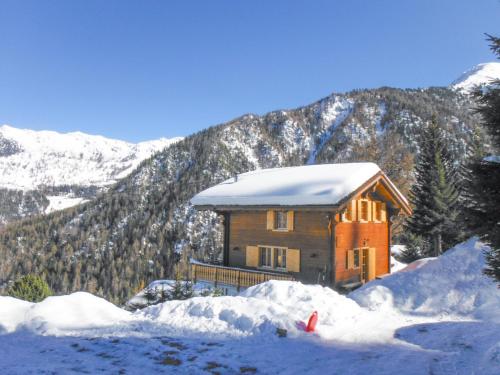 a log cabin in the snow with mountains in the background at Chalet les Bubus in La Tzoumaz