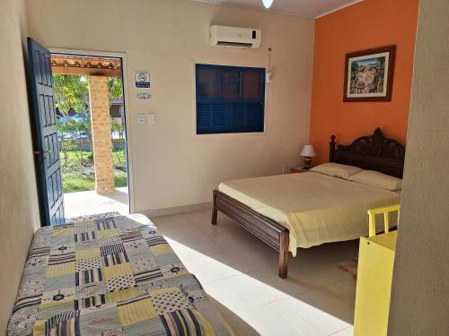 a bedroom with a bed and an open door at Casa na Praia com Piscina in Costa Dourada