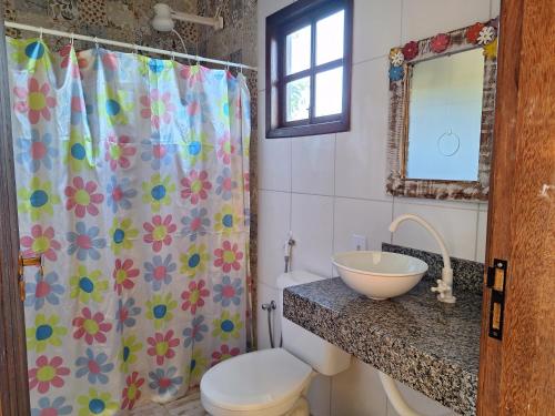 ein Bad mit einem Waschbecken und einem Duschvorhang in der Unterkunft Casa na Praia com Piscina in Costa Dourada
