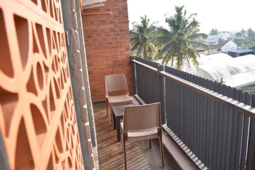 two chairs and a table on a balcony at SScoconest Luxury Service Apartments in Chikmagalūr